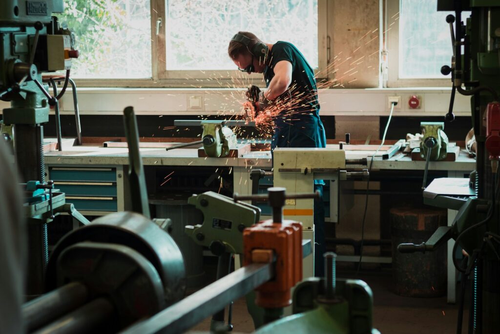 Craftsman using a power tool on the factory floor